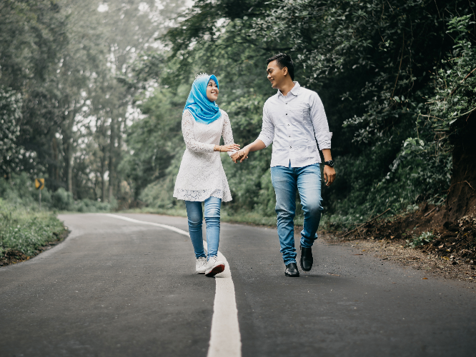 a couple walking hand in hand in a park
