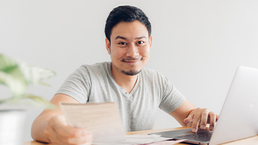 Image of an adult writing on a whiteboard or writing on a notebook with a calculator at the side