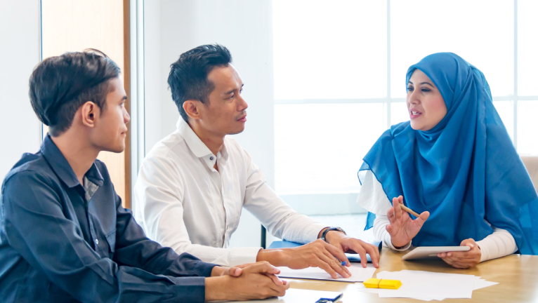 Three people having a discussion in an office
