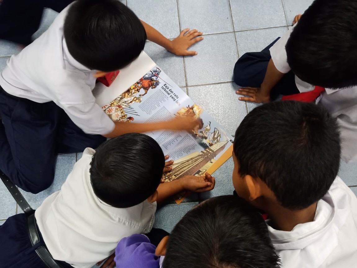 Five children reading a book