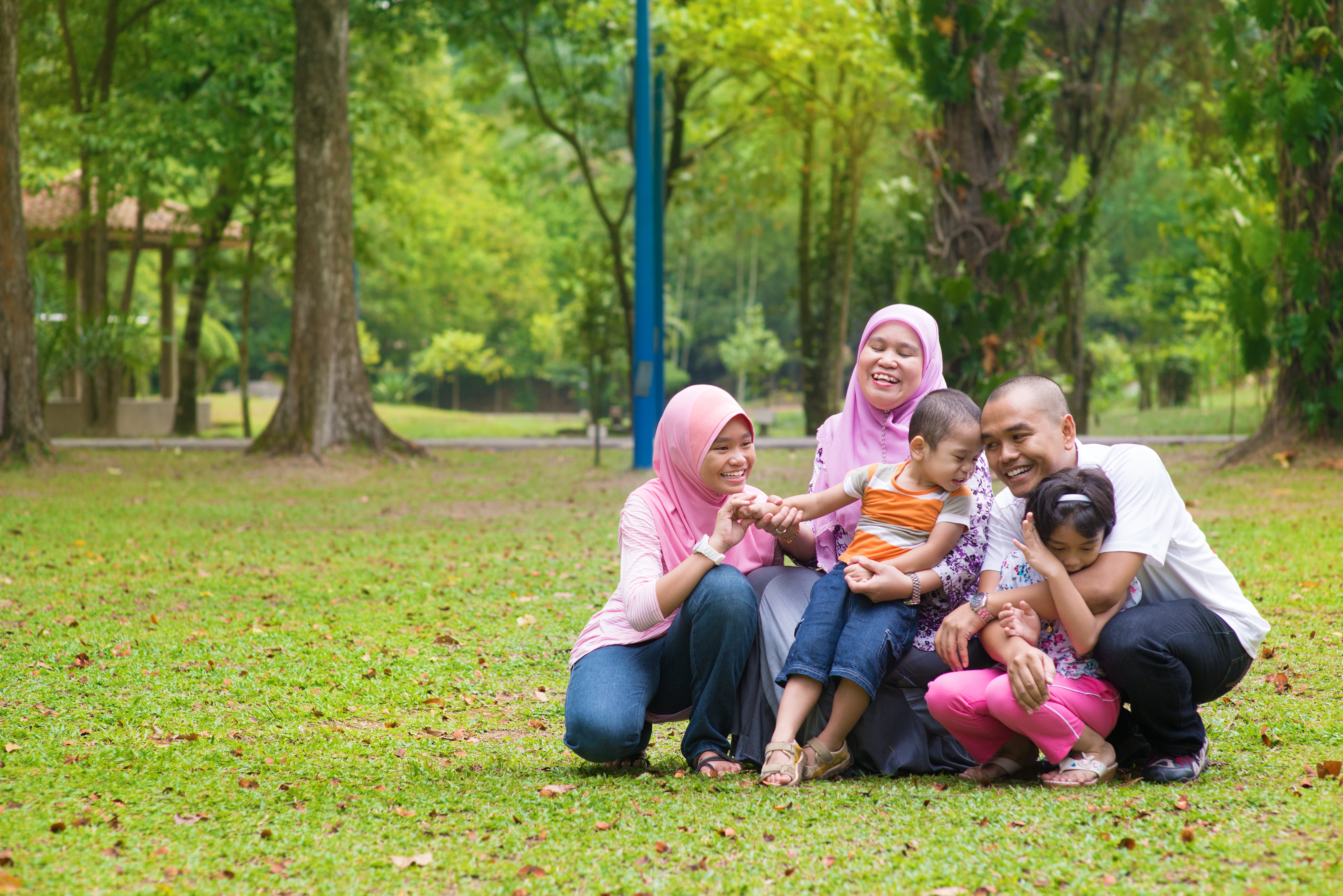 Happy family having fun at outdoor green lawn