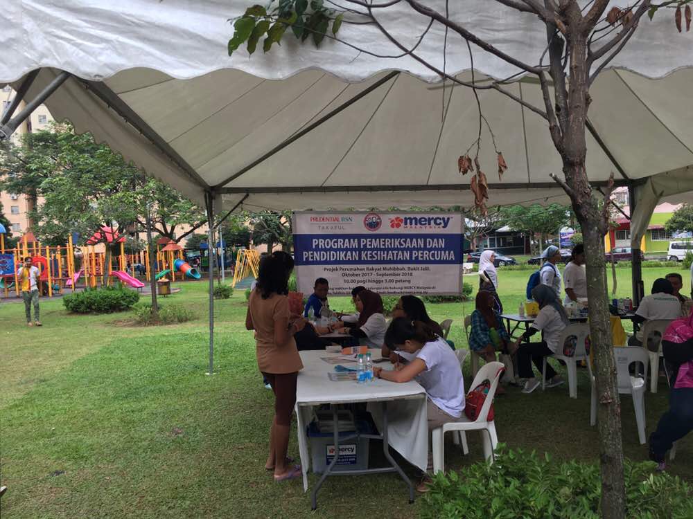 Sukarelawan dengan sepanduk di belakang mereka.