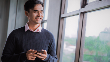 Image of an adult smiling while holding tab/ipad/mobile phone