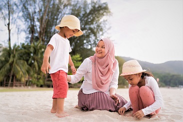 Seorang gadis berbaring di padang rumput sambil memegang payung 