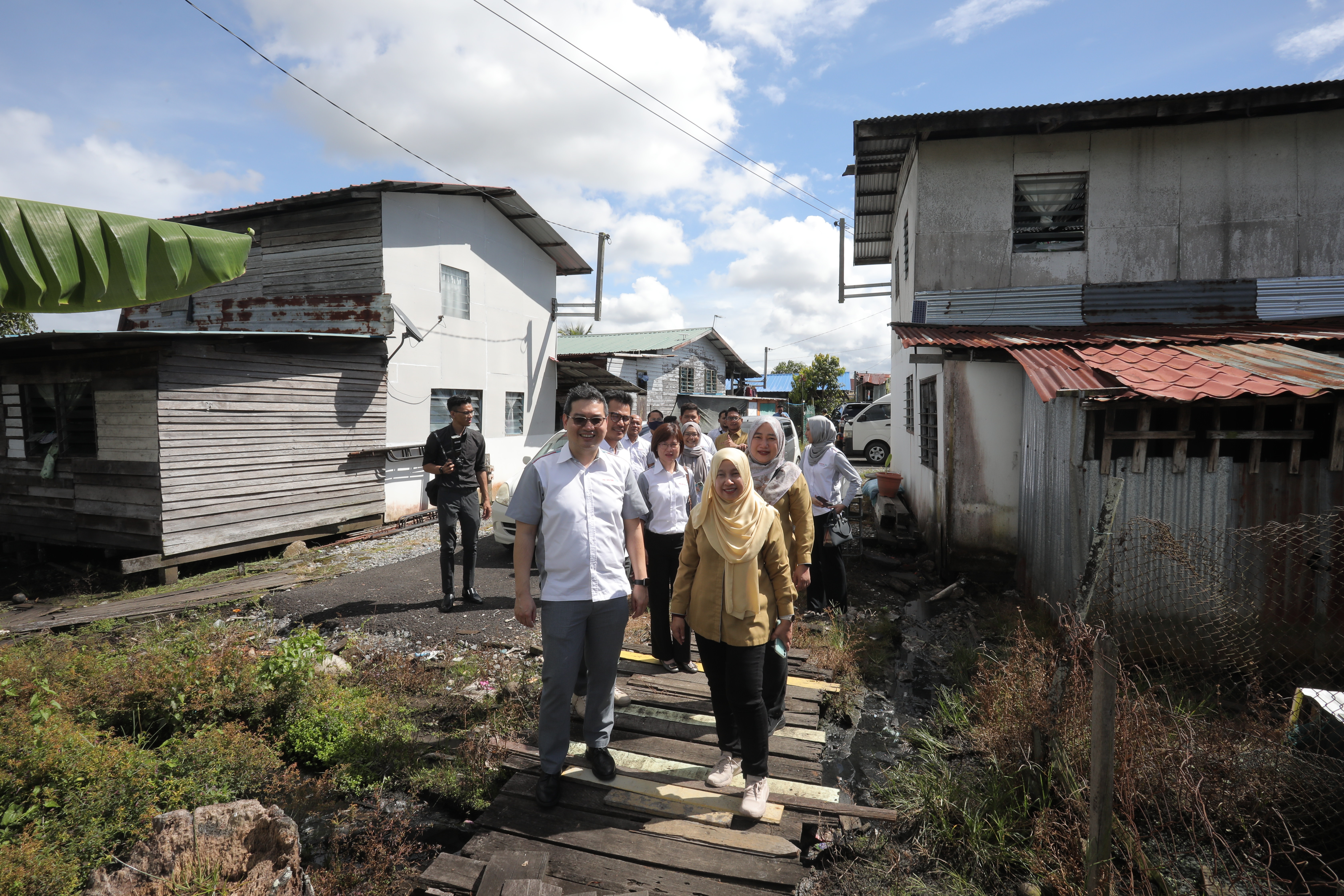 Dua orang pekerja membantu seorang ahli
